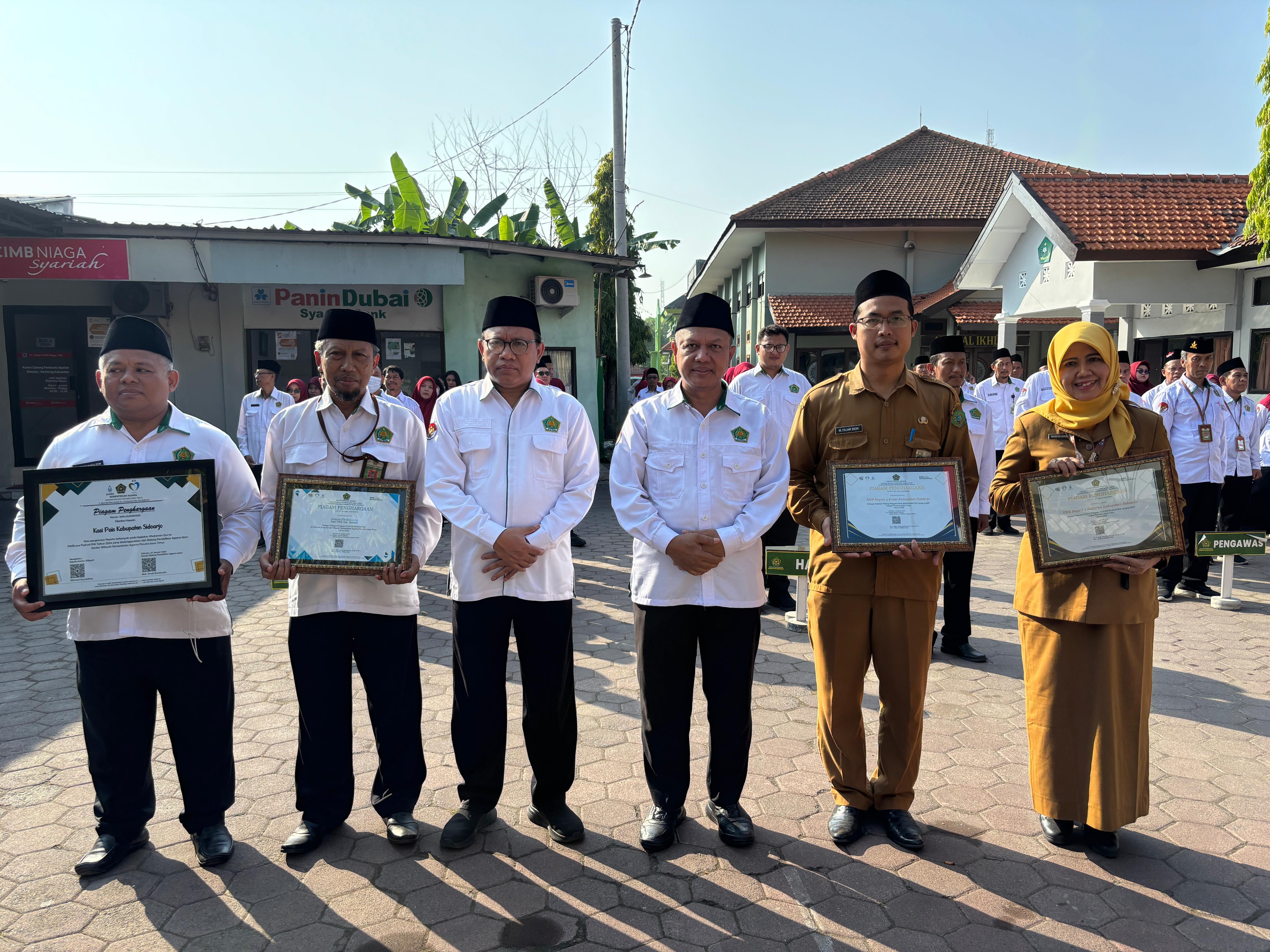 FOTO BERSAMA: Kepala SMPN 3 Krian Fajar Sidik,S.Pd.I.,M.Pd (dua dari kanan) didampingi kantor Kemenag Sidoarjo Drs.Mufi Imron Rosyadi. (ANAS/ RADAR SIDOARJO)