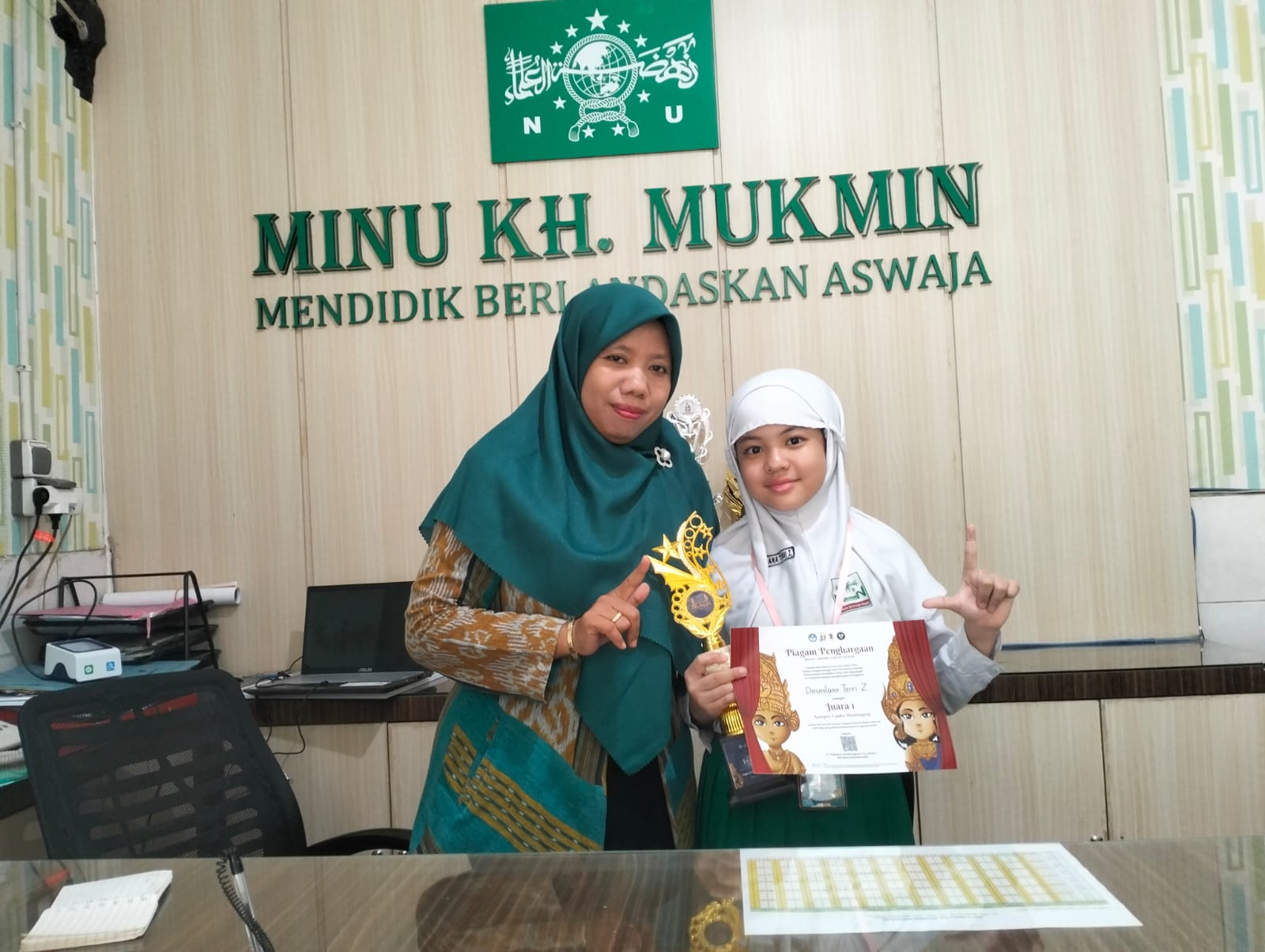 PRESTASI: Kepala MINU KH Mukmin Sidoarjo Hj Anis Faridah bersama Desmilana Tenri Zhafeera saat mengangkat trofi lomba mendongeng Tingkat Jawa Timur. (ANAS/RADAR SIDOARJO)