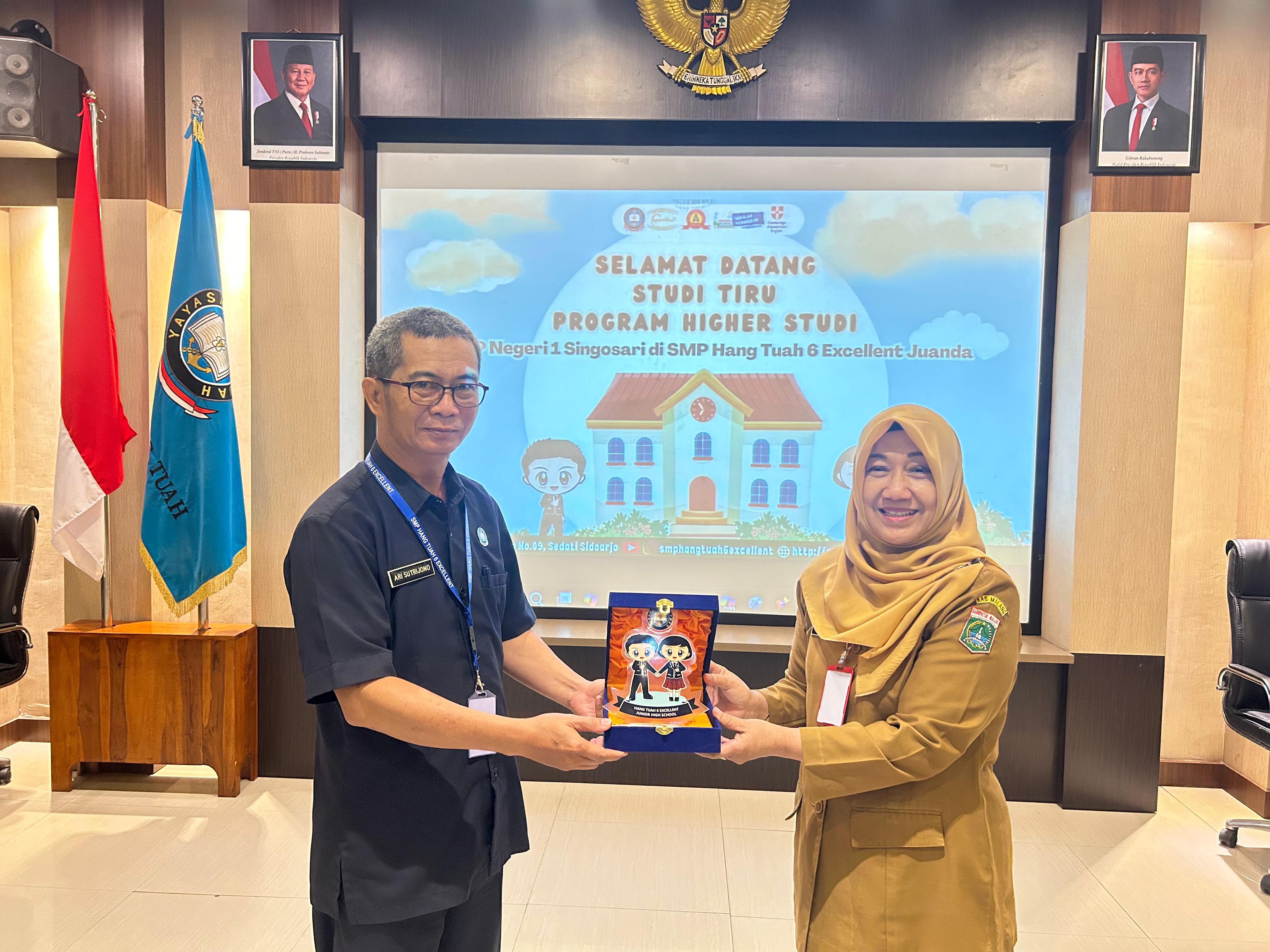 SINERGI : Kepala SMP Hang Tuah 6 Excellent Juanda Ari Sutrijono memberikan cindera mata kepada kepala SMPN 1 Singosari Ana Purwati.(ANAS/RADAR SIDOARJO)