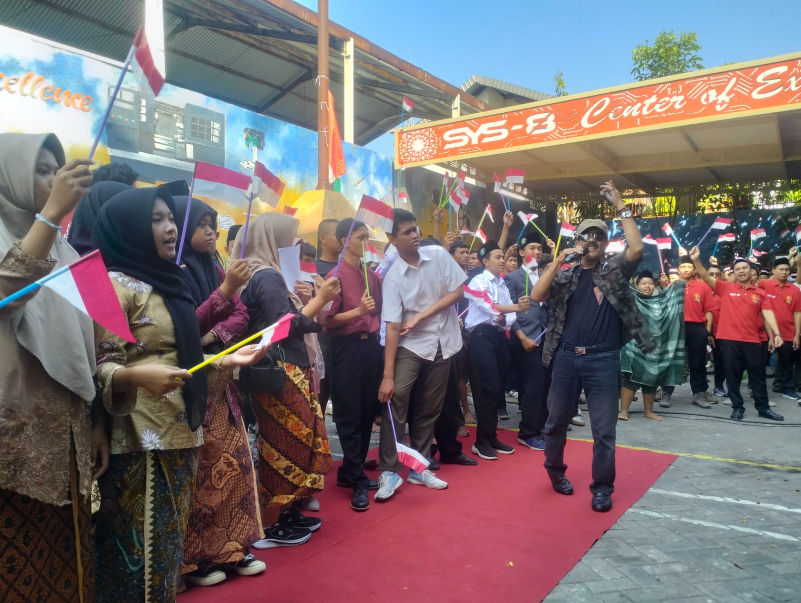 SEMANGAT : Dr. Kisyanto Kepala SMK YPM 8 Sidoarjo saat menyayikan lagu kemerdekaan Indonesia Raya diikuti ribuan siswa, Sabtu (16/8).(ANAS/ RADAR SIDOARJO)