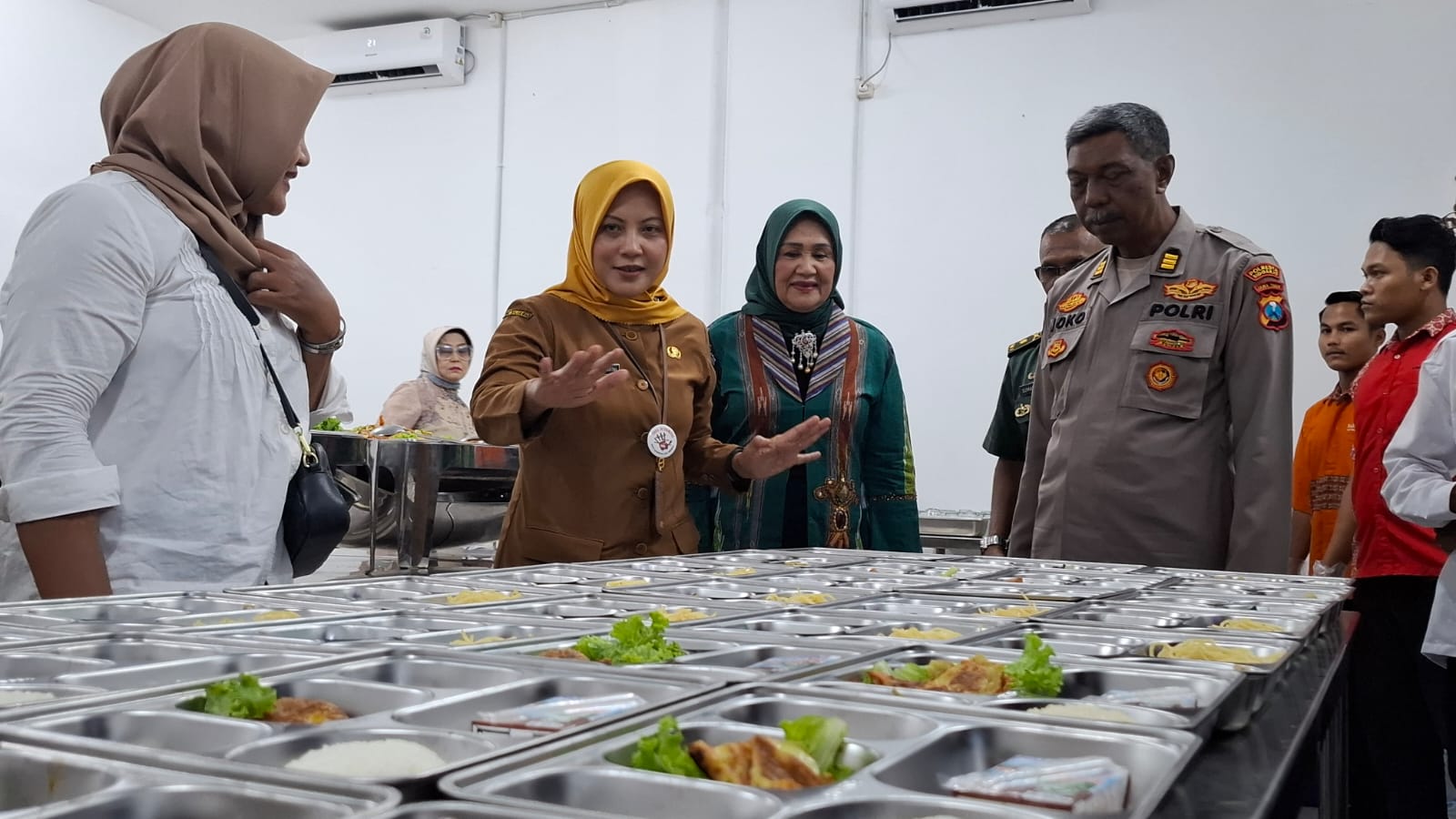 SUDAH BEROPERASI: Plt Kepala Dinas Kesehatan (Dinkes) Sidoarjo, Lakhmie Herawati saat mengecek makanan di dapur SPPG MBG Magersari. (M SAIFUL ROHMAN/RADAR SIDOARJO)
