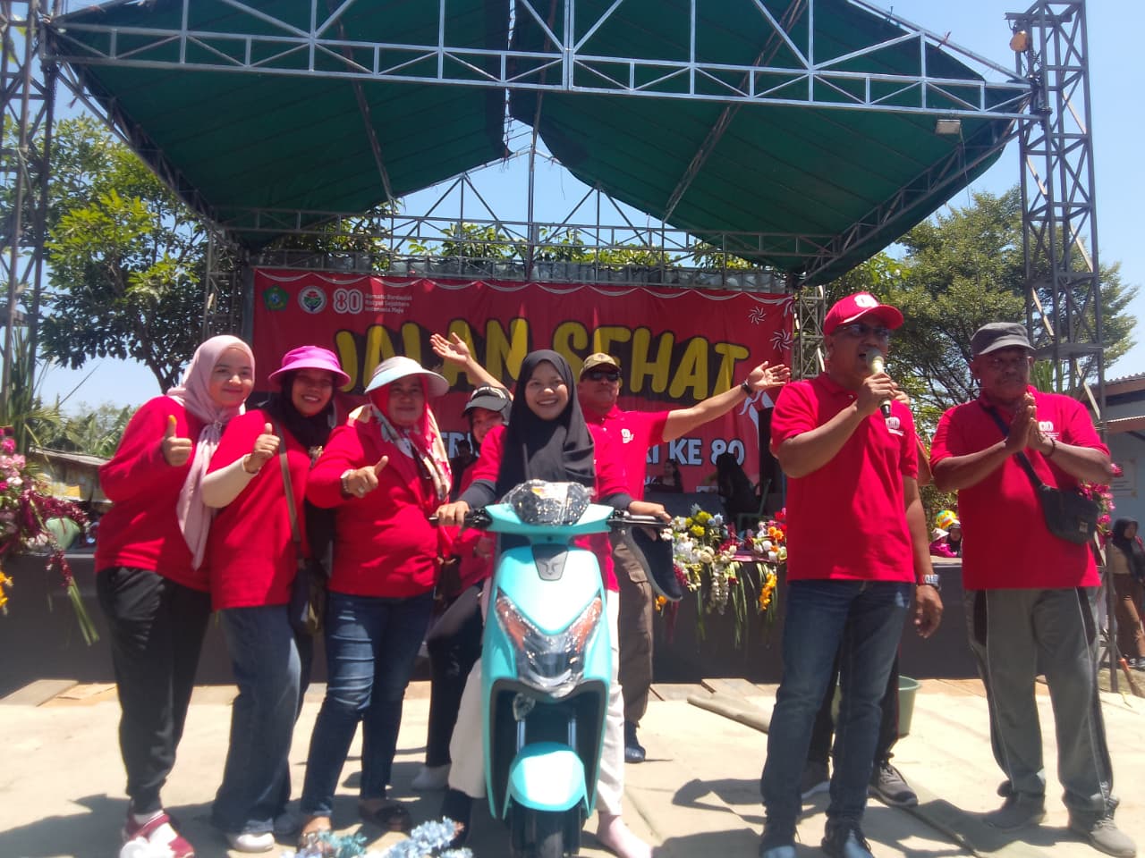 GEMBIRA: Warga mendapat hadiah utama sepeda listrik yang diserahkan oleh Kades Pertapan Maduretno, H. Heru Sutiyo, SE, (topi merah). (DIKY SANSIRI/RADAR SIDOARJO)
