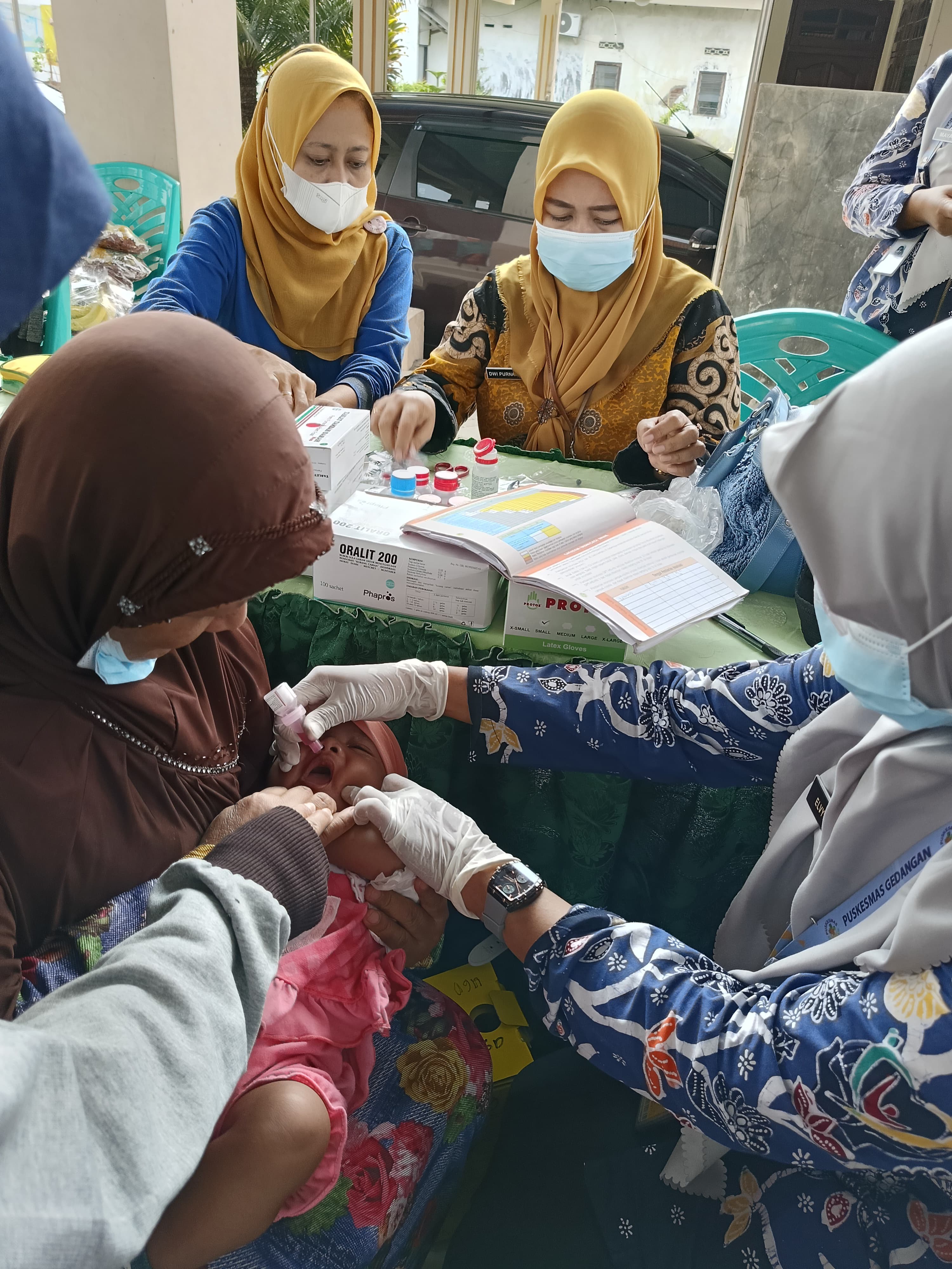 IMUNISASI: Tenaga kesehatan dari Dinkes Sidoarjo saat memeriksa balita.