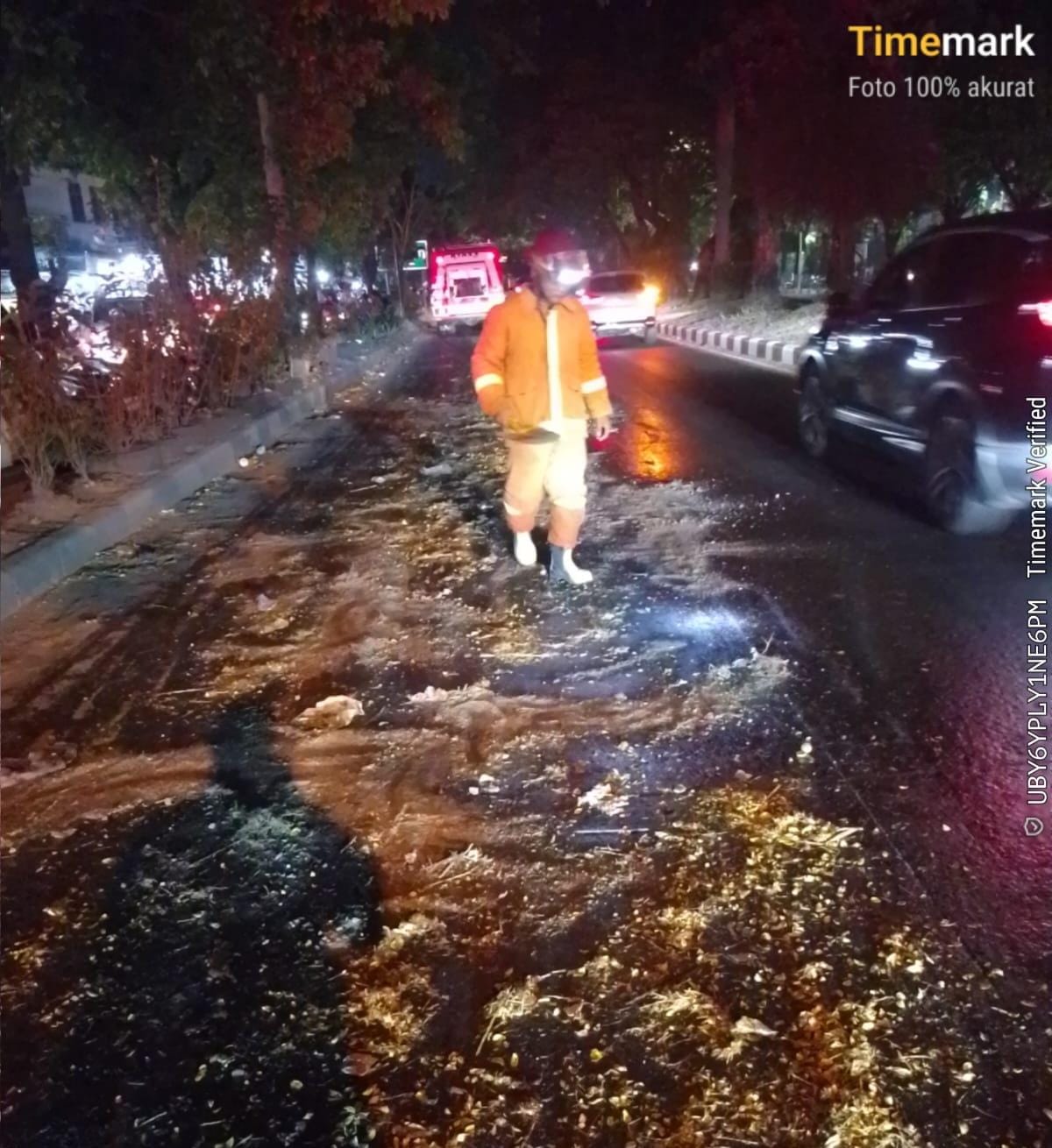 BERBAHAYA : Petugas Damkar Pos Waru sedang membersihkan tumpahan minyak di Jalan Raya Juanda, Sidoarjo.(IST/RADAR SIDOARJO)