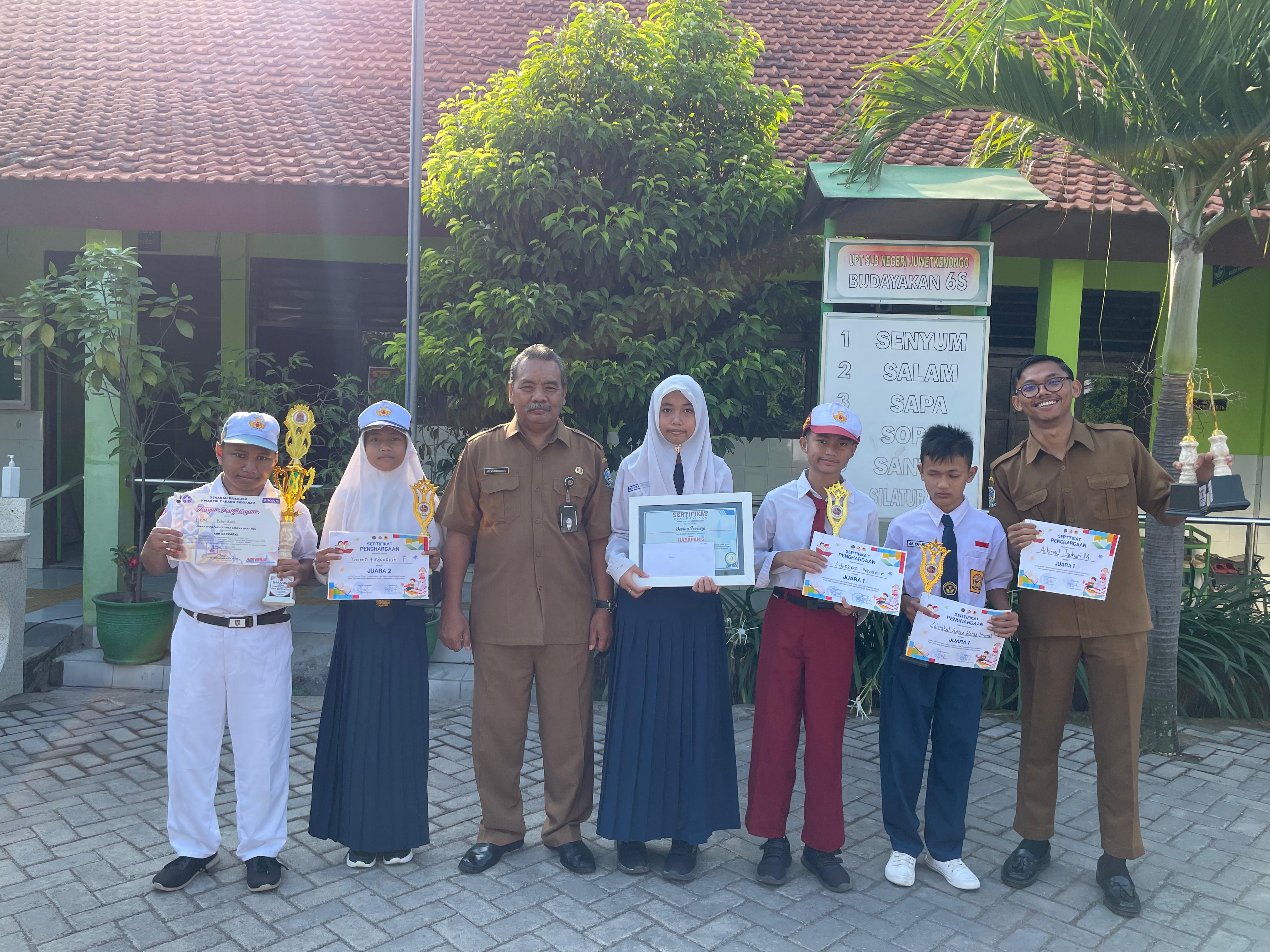 BERPRESTASI: Kepala SLB Negeri Juwet Kenongo Ary Kusmindarto bersama siswa saat mengangkat trofi juara lomba di Disabilitas Festival 2025 di UMSIDA.(ANAS/RADAR SIDOARJO)