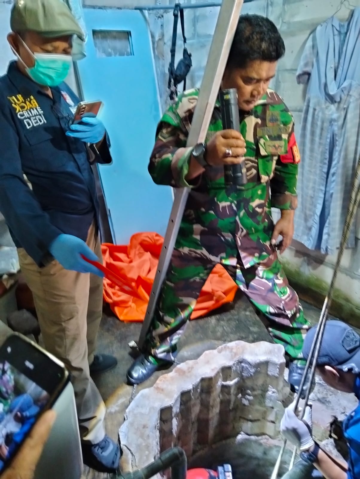 EVAKUASI : Petugas sedang berupaya mengevakuasi korban dari dalam sumur di rumahnya, Sidokare, Sidoarjo.(IST/RADAR SIDOARJO)