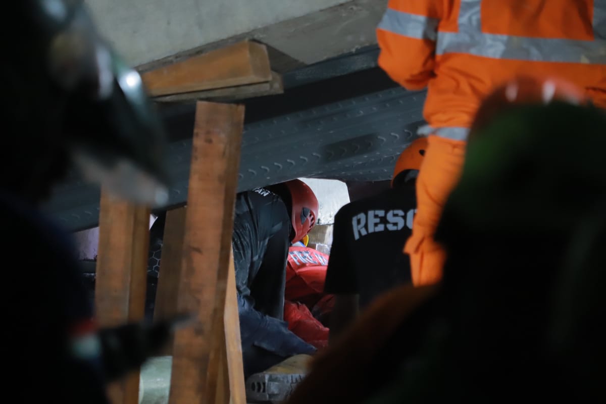 PENUH RISIKO: Petugas masuk ke celah bangunan ambruk.  (SURYANTO/RADAR SIDOARJO)