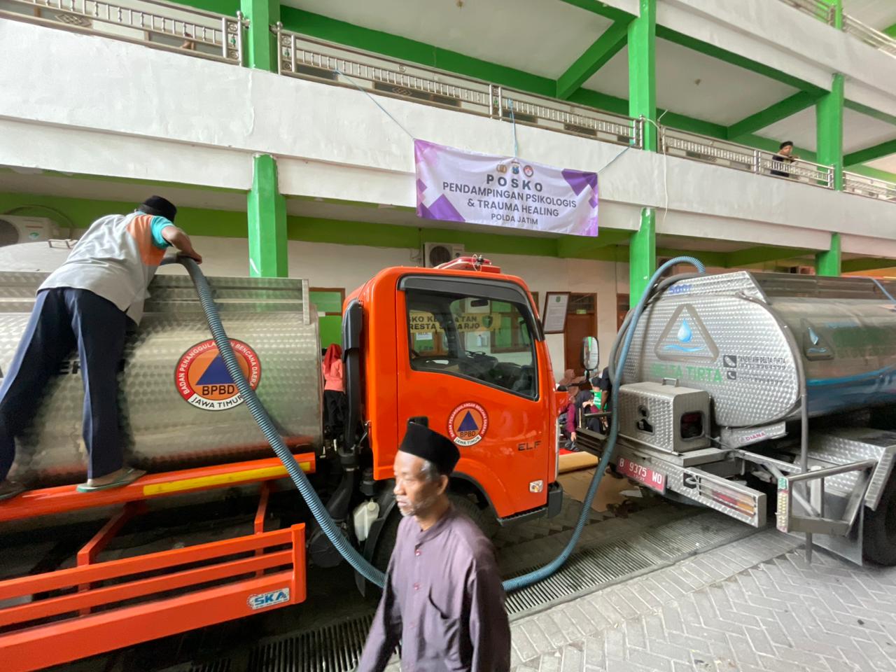 BANTUAN: Truk tangki Perumda Delta Tirta menyalurkan pasokan air bersih ke lokasi posko bencana ambruknya Ponpes Al-Khoziny, Buduran. (M SAIFUL ROHMAN/RADAR SIDOARJO)