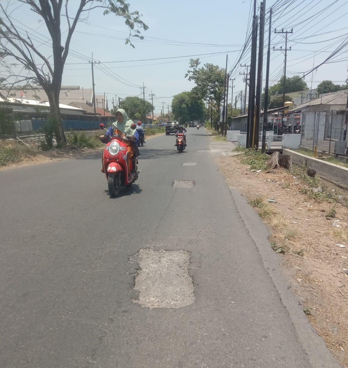 MEMBAHAYAKAN: Sejumlah lubang menganga di Jalan Raya Betro, Sedati, Jumat (10/10). (DIKY SANSIRI/RADAR SIDOARJO)