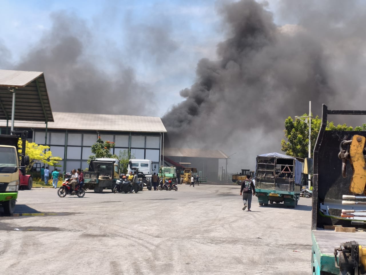 MEMBARA: Asap tebal membumbung tinggi akibat kebakaran gudang perbaikan truk di Porong, Senin (13/10).