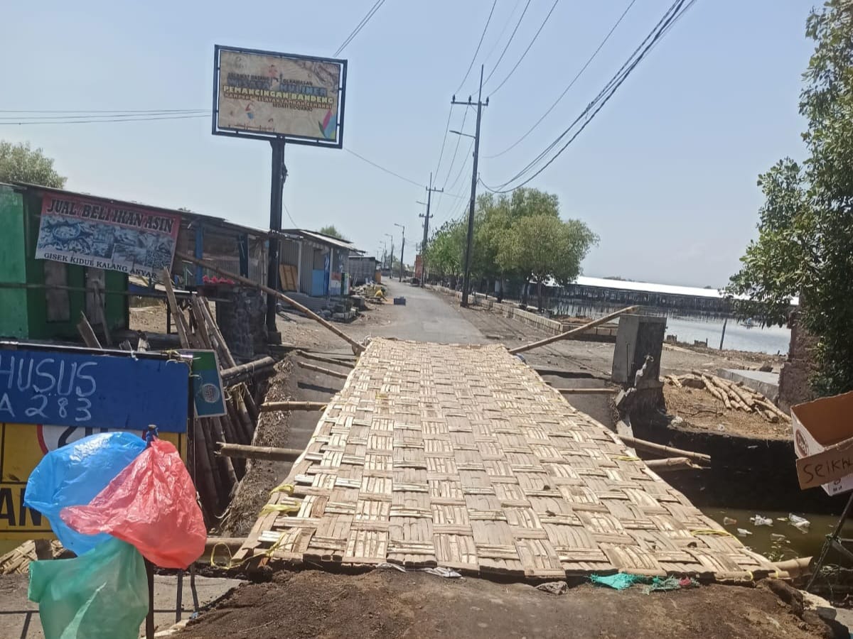 TAK KUNJUNG DIPERBAIKI: Warga Dusun Gisik Kidul, Desa Tambak Cemandi membangun jembatan sementara dari anyaman bambu.&nbsp;