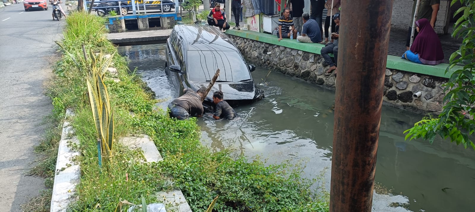 APES: Mobil tercebur ke sungai di Panjunan, Sukodono, Minggu (26/10) pagi.