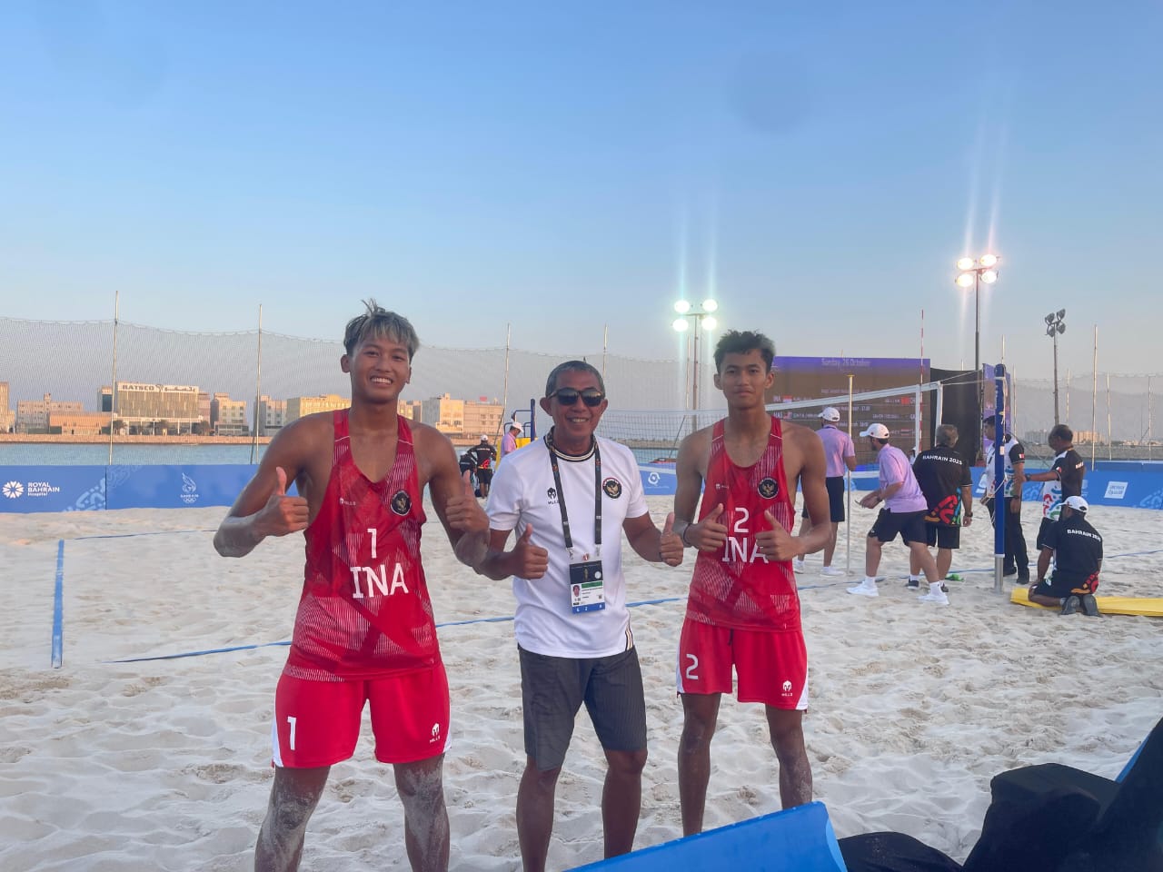 BERPRESTASI: Atlet voli pantai asal Sidoarjo, Hafiyan Azam Nurudin (kiri), bersama pelatihnya Bambang Eko Suhartawan (tengah) memamerkan medali perunggu yang diraih di ajang Asian Youth Games 3rd 2025
