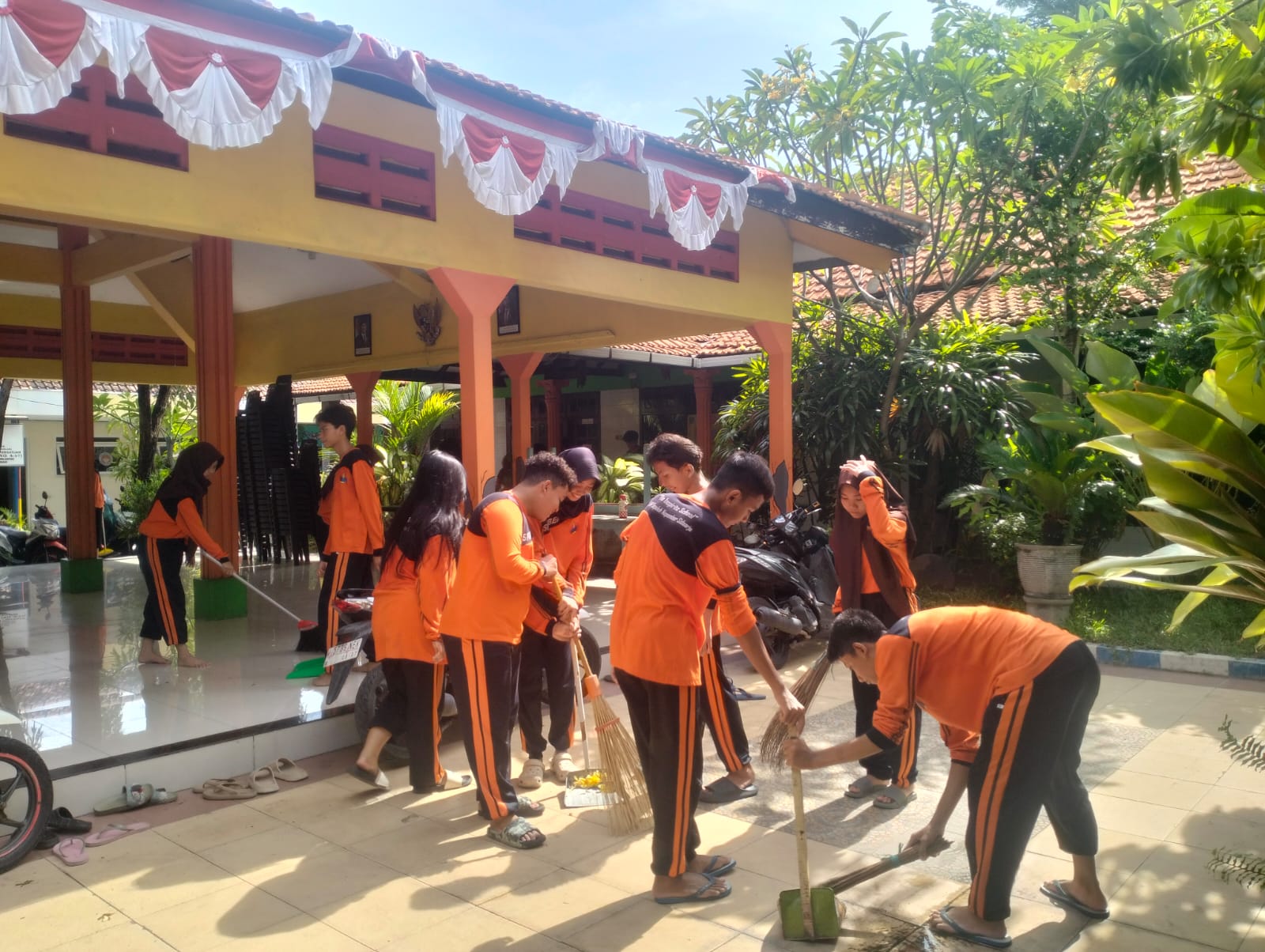 KOMPAK: Siswa SMP Sepuluh Nopember Sidoarjo bersemangat gelar Aksi Cepat Bersih lingkungan Balai Desa Siwalanpanji. (ANAS/RADAR SIDOARJO)