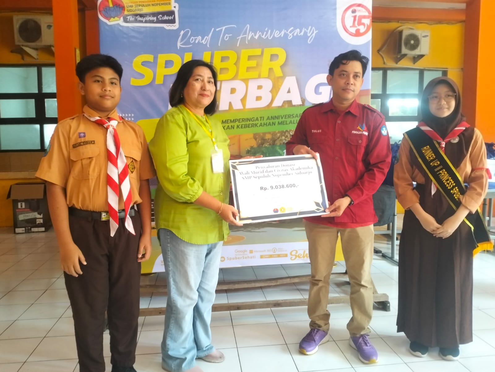 BERBAGI: Penyerahan secara simbolis oleh kepala SMP Sepuluh Nopember Sidoarjo Spuber Saiful Tulus Jatmika, S.Pd., M.Pd..diberikan kepada wali murid. (ANAS/RADAR SIDOARJO)