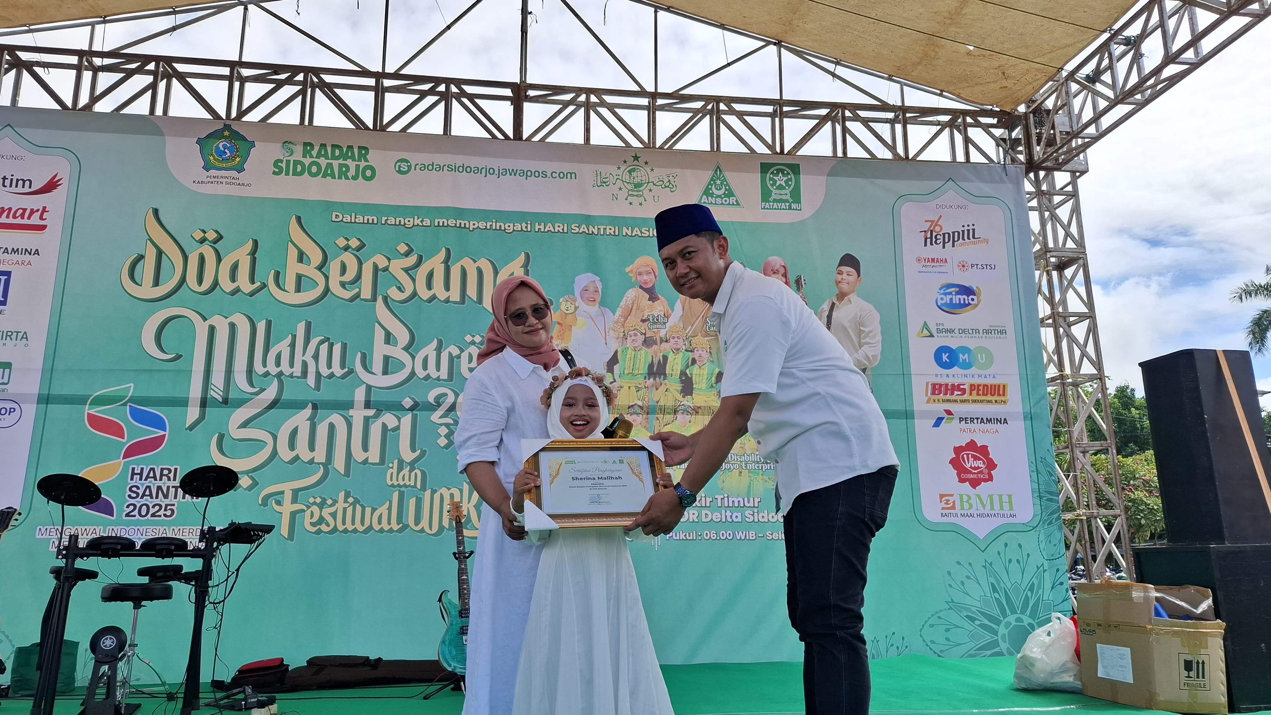 BERBAKAT: Kabiro Radar Sidoarjo, Vega Dwi Arista (kanan) memberikan penghargaan untuk Sherina pada Acara Mlaku Bareng Santri Radar Sidoarjo. Minggu (2/11).(M SAIFUL ROHMAN/RADAR SIDOARJO)
