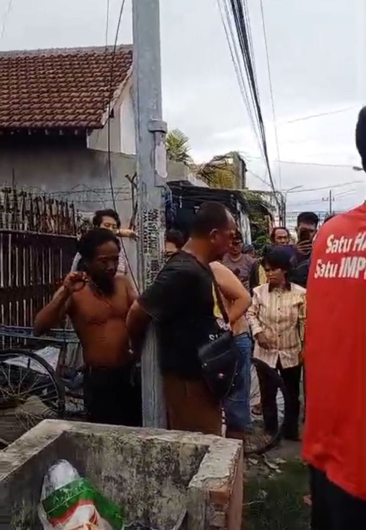 MERESAHKAN: Warga mengikat tersangka pencurian motor, MKA (baju hitam) di tiang listrik, Lemahputro, Sidoarjo, Minggu (2/11) sore.