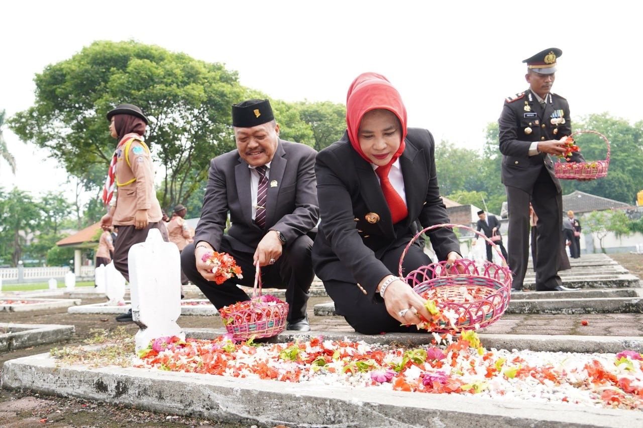 PENGHORMATAN: Wakil Bupati Sidoarjo Mimik Idayana menaburkan bunga di makam pahlawan. (M SAIFUL ROHMAN/RADAR SIDOARJO)