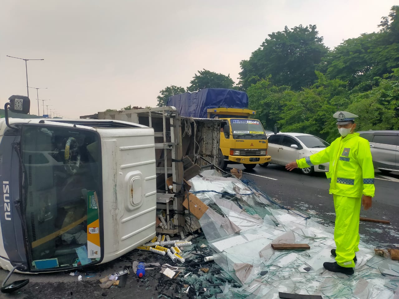 APES: Truk bermuatan kaca terguling di Tol Waru arah Sidoarjo, Senin (10/11).  &nbsp;