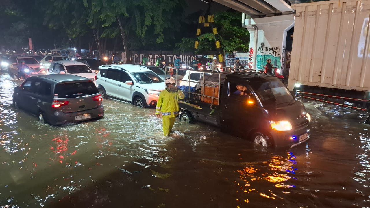 MACET: Kendaraan melintasi genangan air di bawah jalan tol depan Lippo Plaza Sidoarjo. (M SAIFUL ROHMAN/RADAR SIDOARJO)