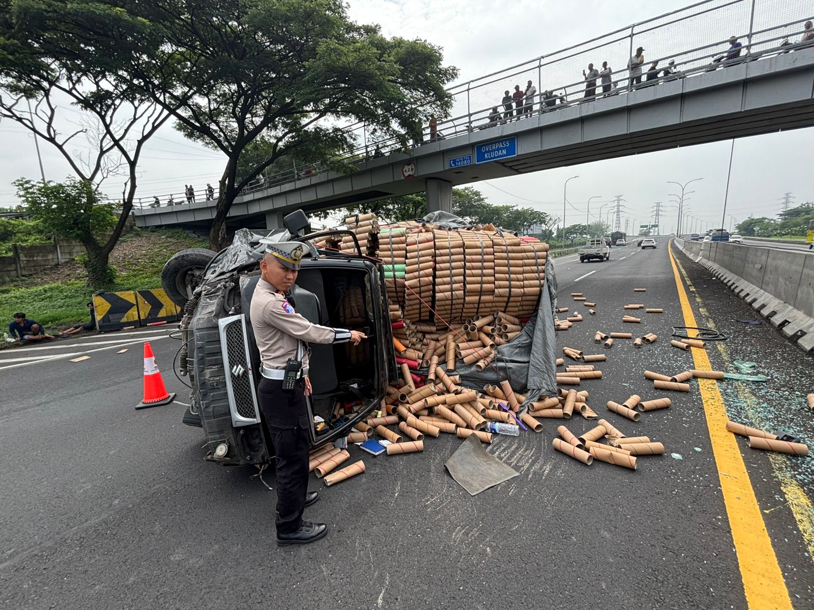 MACET: Sebuah pikap bermuatan gulungan kertas terguling di Tol Sidoarjo arah Porong, Selasa (11/11). (DIKY SANSIRI/RADAR SIDOARJO)