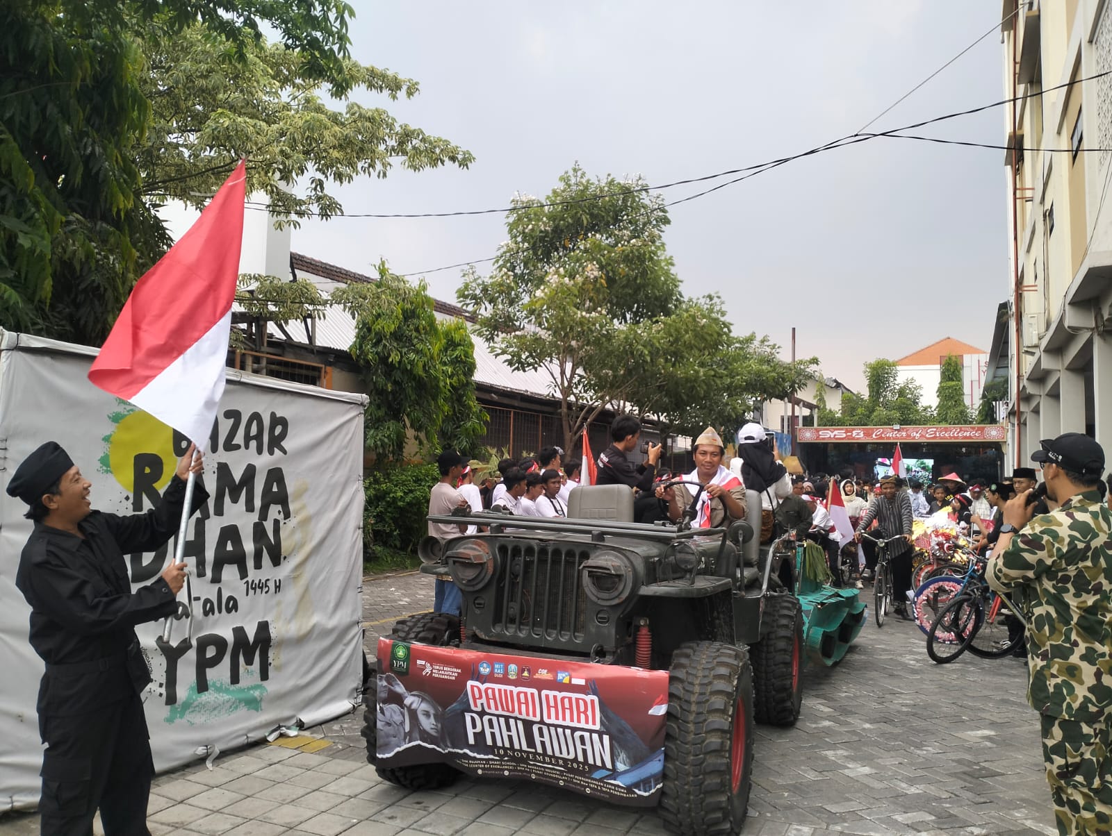 SEMARAK: Waka kurikulum Dr. Aftoni saat memberangkatkan pawai siswa SMK YPM 8 Sidoarjo. (ANAS/RADAR SIDOARJO)