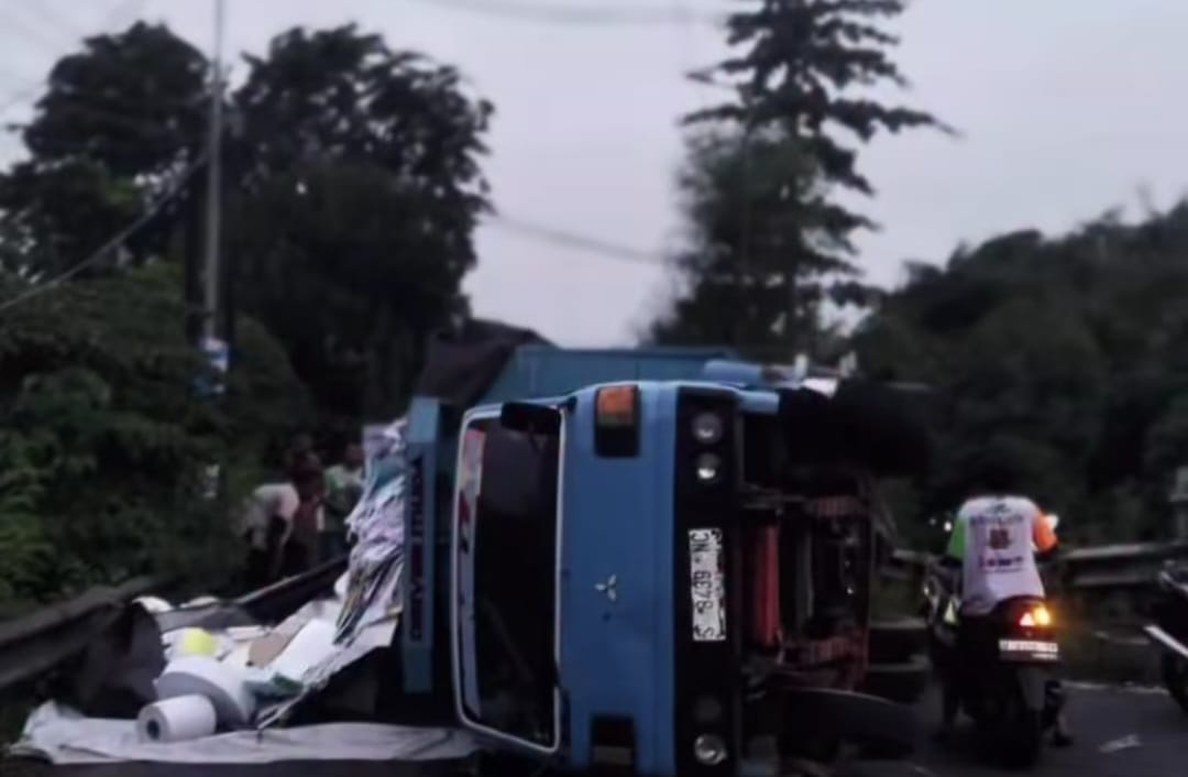 TIKUNGAN TAJAM: Truk terguling di Overpass Masangan Wetan Sukodono, Selasa (11/11) petang. (DIKY SANSIRI/RADAR SIDOARJO)