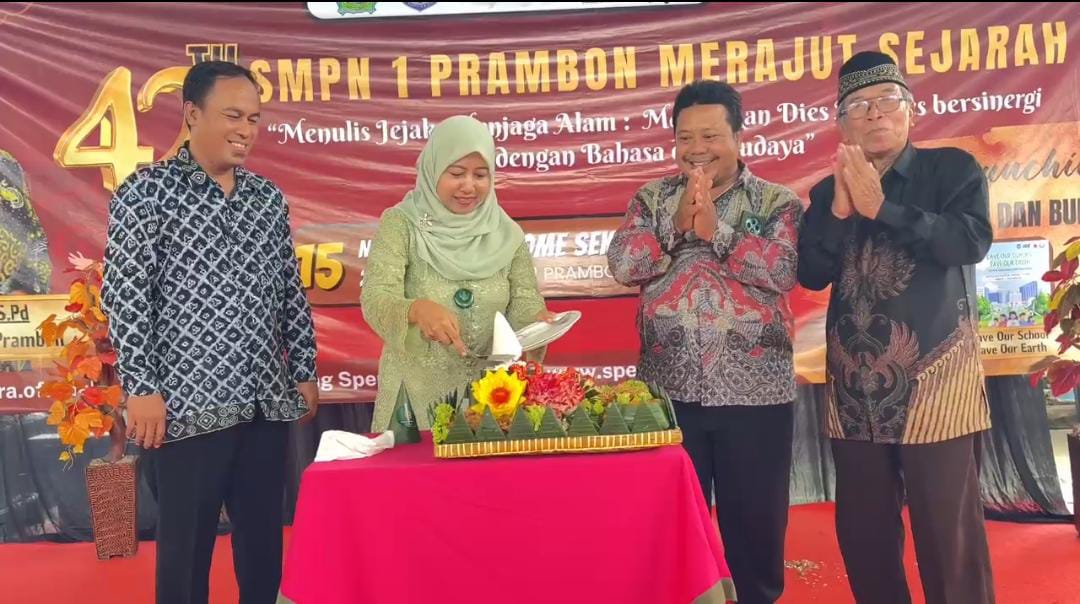 BERSYUKUR: Kepala SMPN 1 Prambon, Yekti Eriani, S.Pd., melakukan potong tumpeng sebagai rasa syukur dalam perayaan Dies Natalis ke-42.(IST/RADAR SURABAYA)