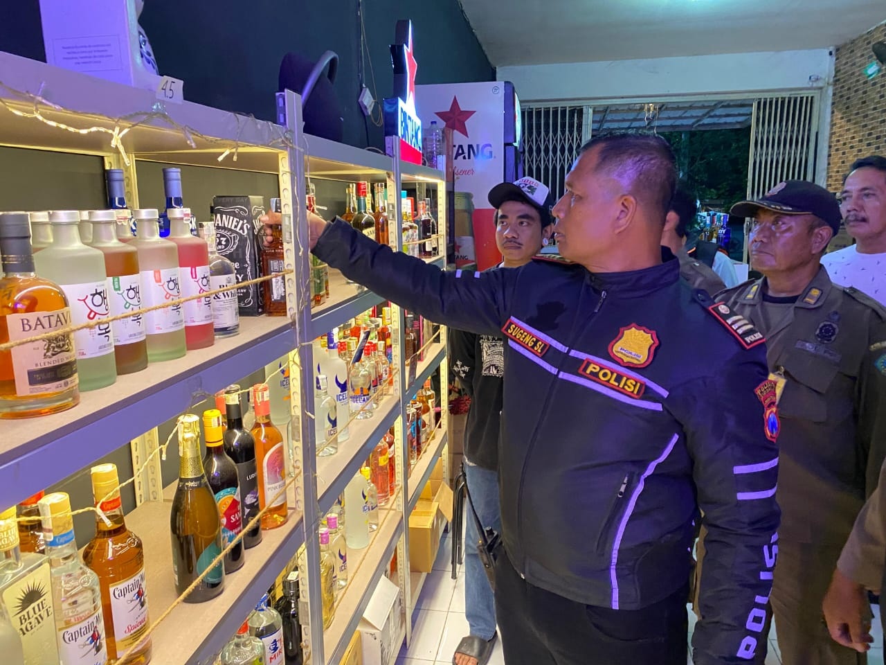 TEGAS: Kapolsek Balongbendo AKP Sugeng Sulistiyono mengecek toko miras di Balongbendo, Sidoarjo, Minggu (16/11) malam. (DIKY SANSIRI/RADAR SIDOARJO)