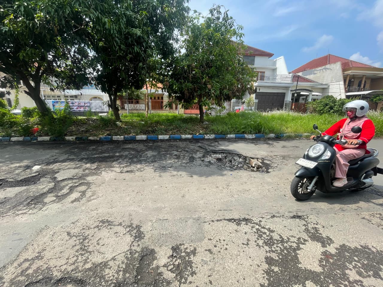 RUSAK: Kondisi jalan di Sidokare tampak berlubang usai banjir surut. (M SAIFUL ROHMAN/RADAR SIDOARJO)