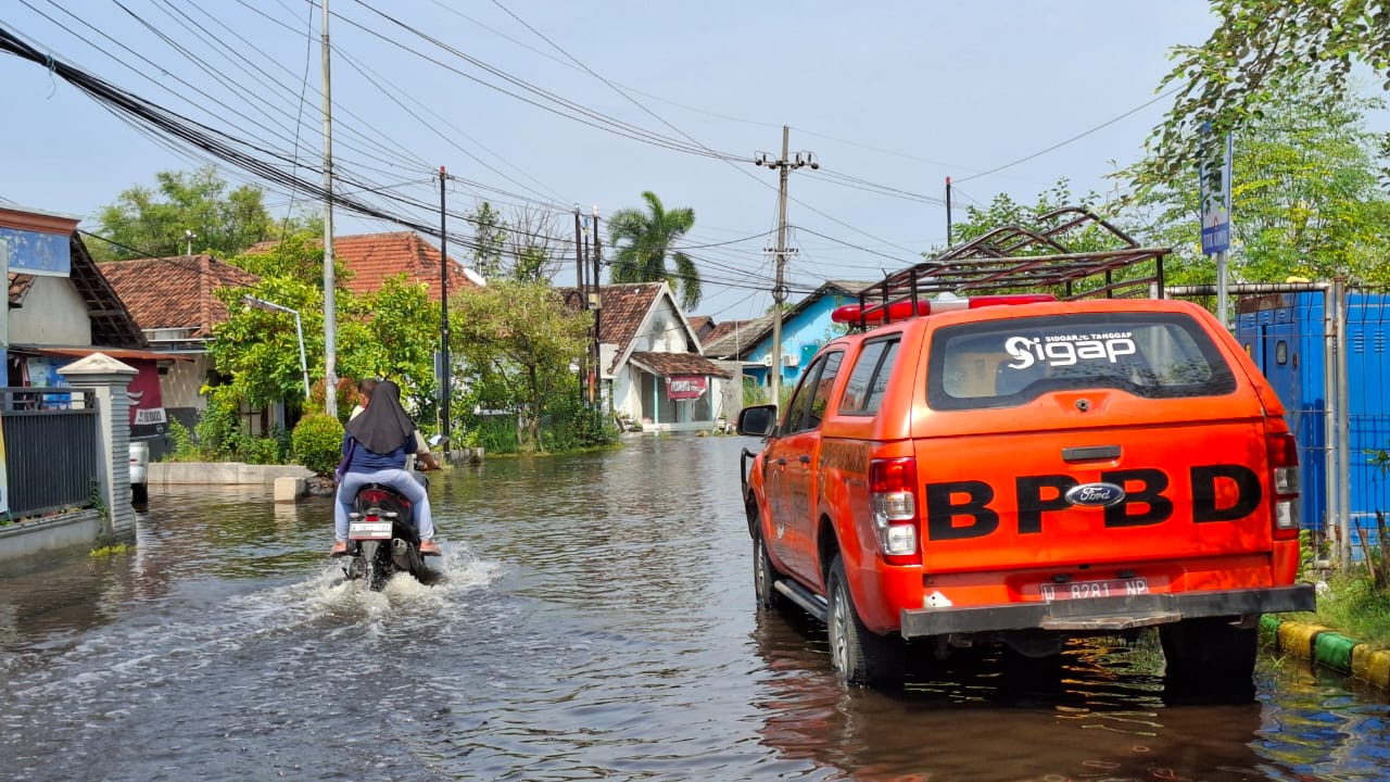 DIKELUHKAN WARGA: BPBD siaga di kawasan banjir di Desa Banjarasri. (M SAIFUL ROHMAN/RADAR SIDOARJO)