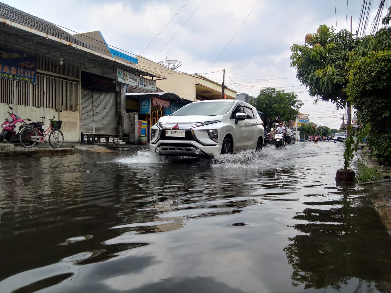 ANTISIPASI: Banjir menggenangi Jalan Wisma Tropodo, Kecamatan Waru akibat hujan deras. (DIKY SANSIRI/RADAR SIDOARJO)