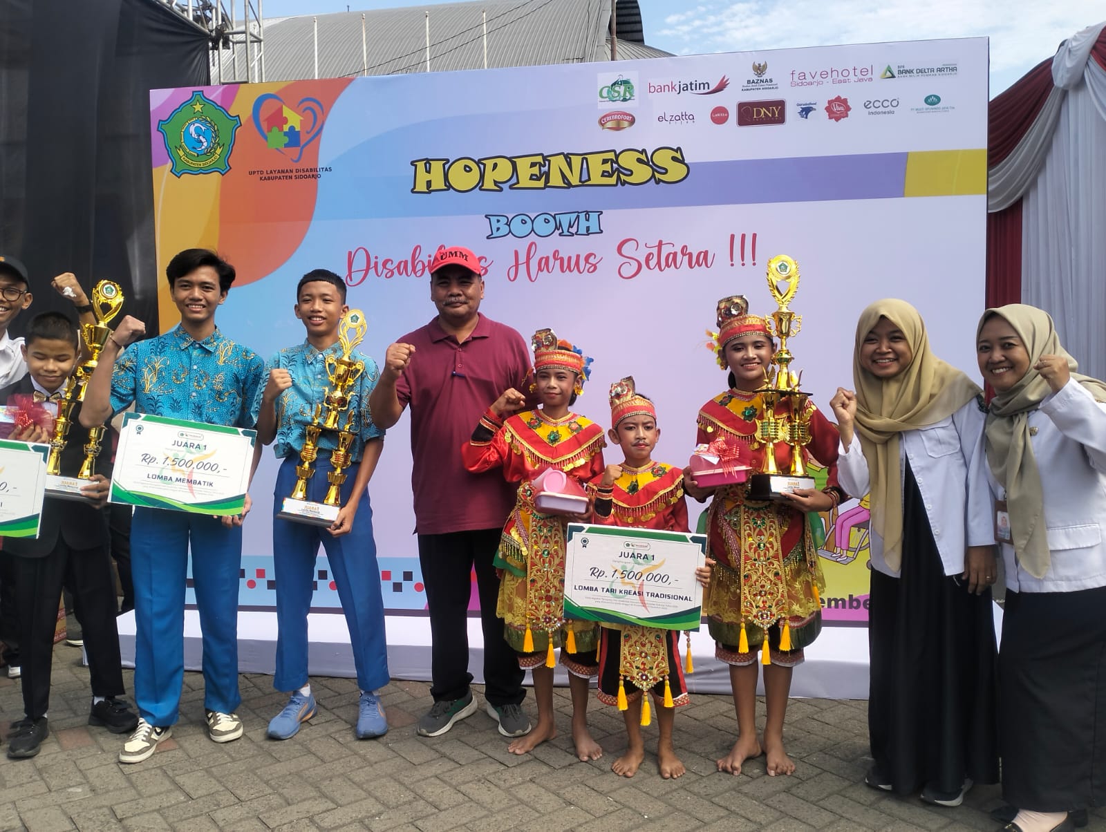 BANGGA: Kepala SLB Juwet Kenongo Ary Kusmindarto bersama siswa mengangkat piala juara 1 Menyanyi,Menari,Batik dalam Hari Disalibitas Internasional Kabupaten Sidoarjo 2025. (ANAS/RADAR SIDOARJO)