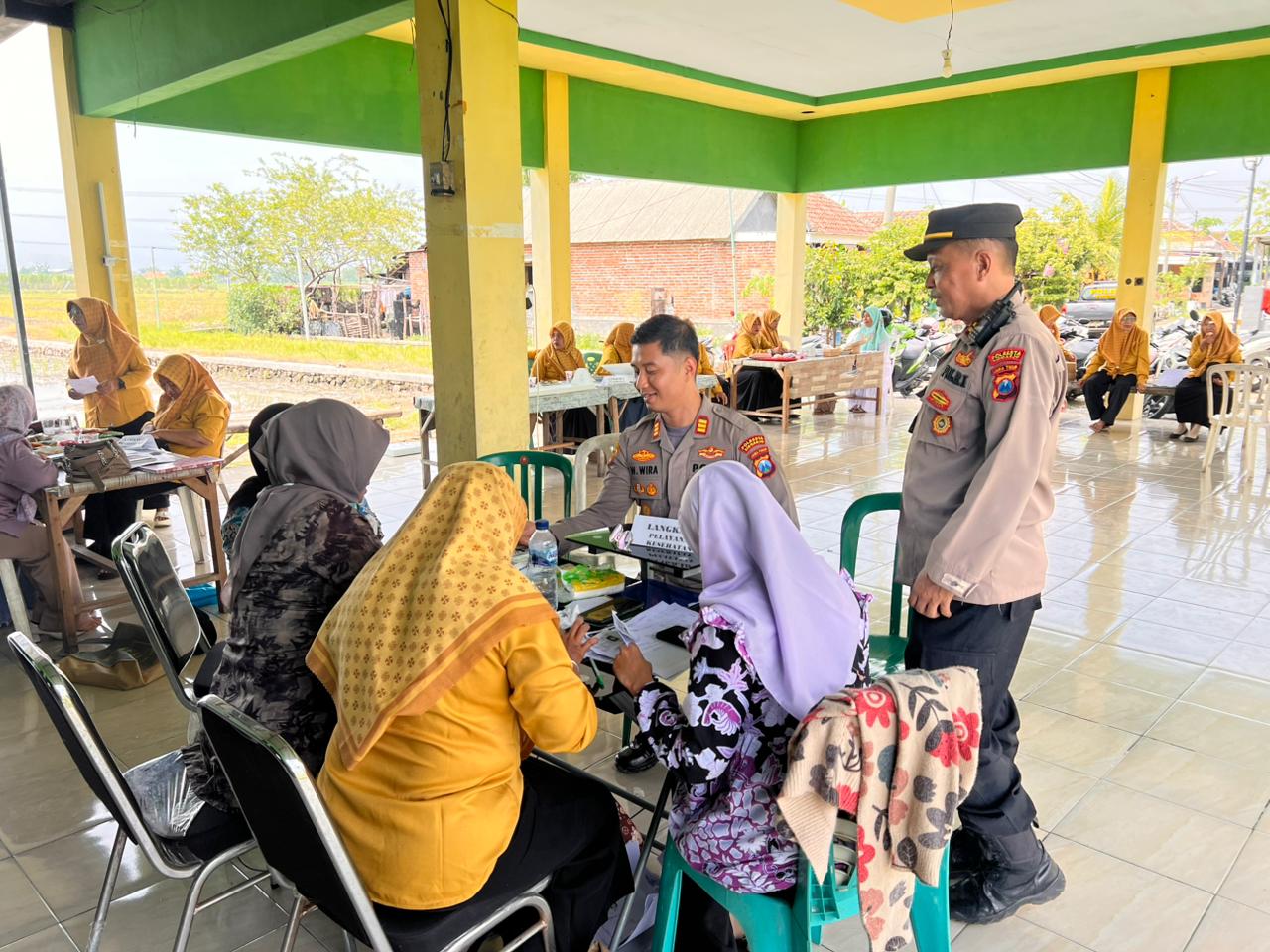 KESEHATAN: Kapolsek Krembung AKP I Wayan Wiratmaja Swetha (dua dari kanan) dan jajaran saat meninjau pelaksanaan Posyandu di Desa Wangkal, Krembung.