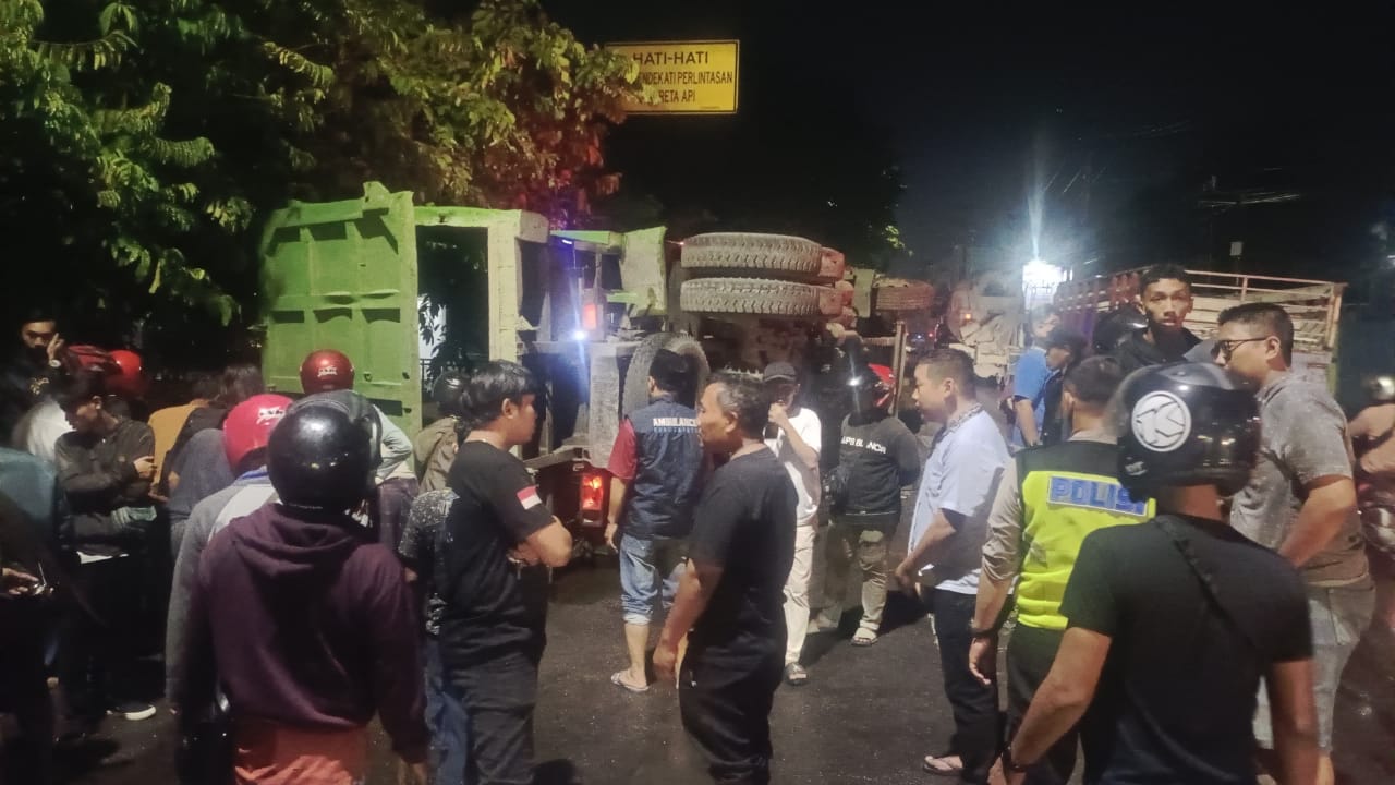 TERGULING: Kecelakaan lalu lintas yang terjadi di Krian, Sidoarjo, Kamis (18/12) malam melibatkan sebuah truk tronton dan sepeda motor matik.