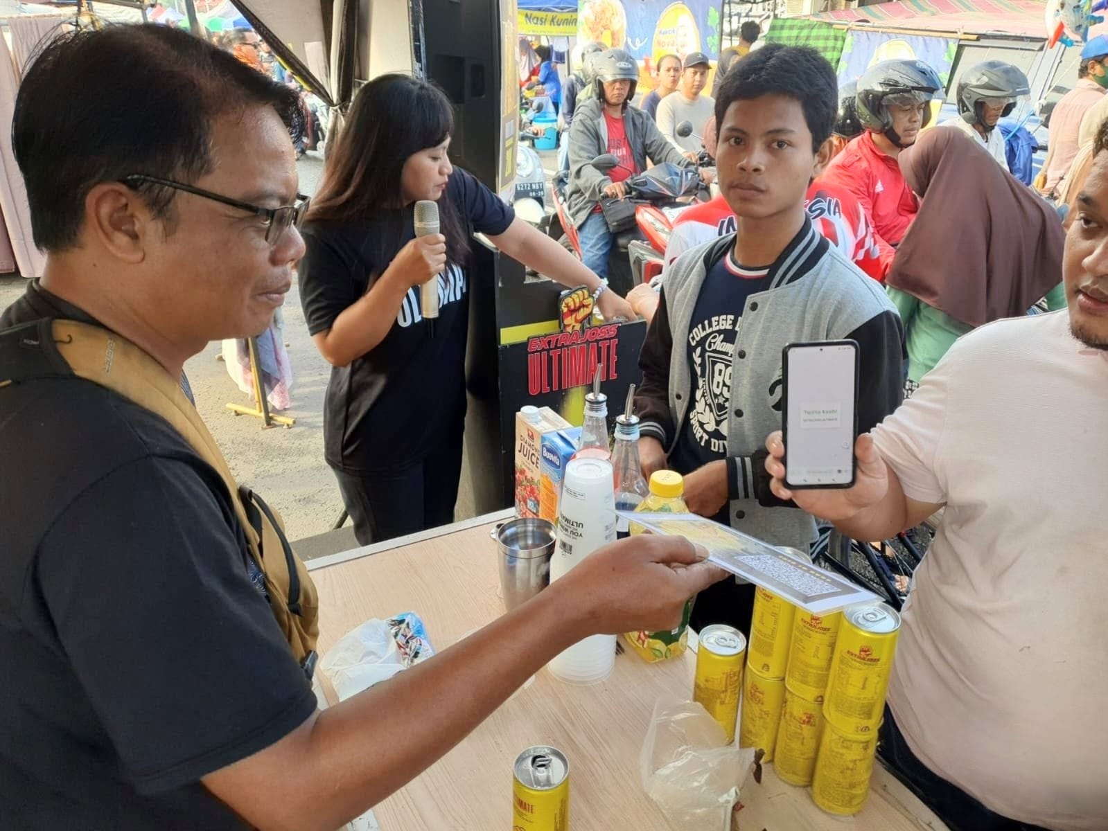 SCAN BARCODE: Seorang pengunjung memindai barcode di booth Extra Joss Ultimate sebagai bentuk partisipasi sekaligus menyampaikan ucapan terima kasih atas aktivitas yang dihadirkan.(IST/RADAR SIDOARJO)