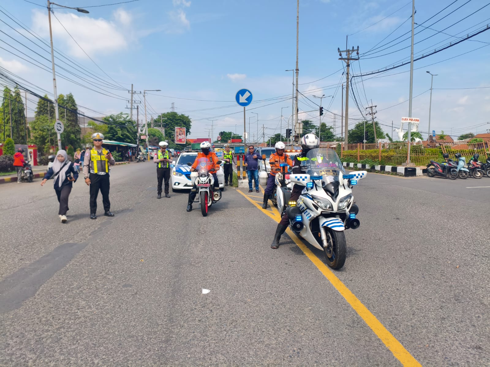 DIMULAI: Personel Satlantas Polresta Sidoarjo saat mensosialisasikan pemberlakukan one way di Jalan Letjen Sutoyo, Sidoarjo, selama Nataru.(SURYANTO/RADAR SIDOARJO)