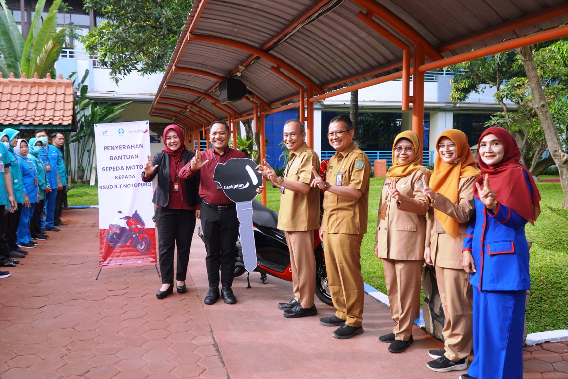 SINERGITAS: Pimpinan Bank Jatim Cabang Sidoarjo Suyatno (memegang kunci) saat menyerahkan bantuan motor kepada Direktur RSUD RT Notopuro Sidoarjo, dr Atok Irawan, Senin (22/12).