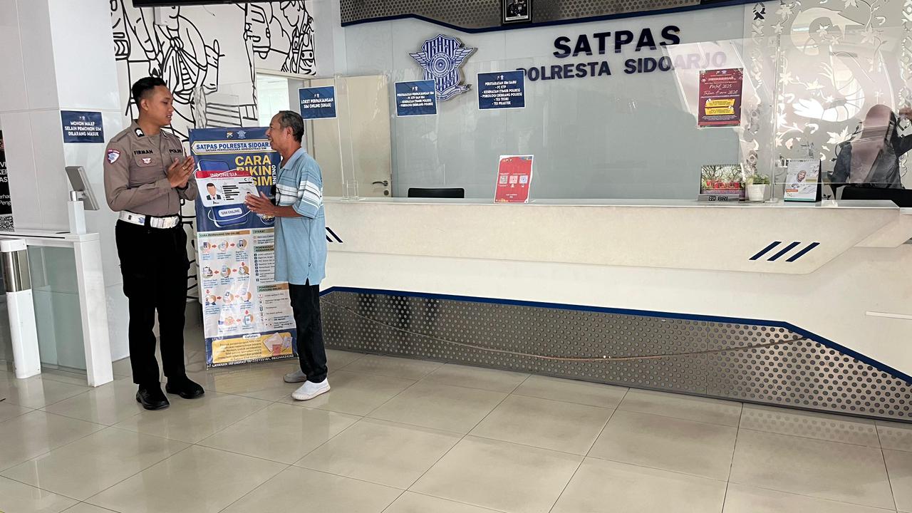PUAS: Petugas Satpas Polresta Sidoarjo saat membantu salah satu pemohon perpanjangan SIM menggunakan aplikasi SINAR. (IST/RADAR SIDOARJO)