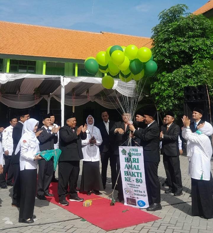 SINERGI: Kepala Kantor Kemenag Sidoarjo Dr H.Moh.Mufi Imron Rosyadi saat pelepasan balon dalam kegiatan upacara bendera dalam rangka Hari Amal Bakti ke-80 di MTsN 4 Sidoarjo. (ANAS/RADAR SIDOARJO)