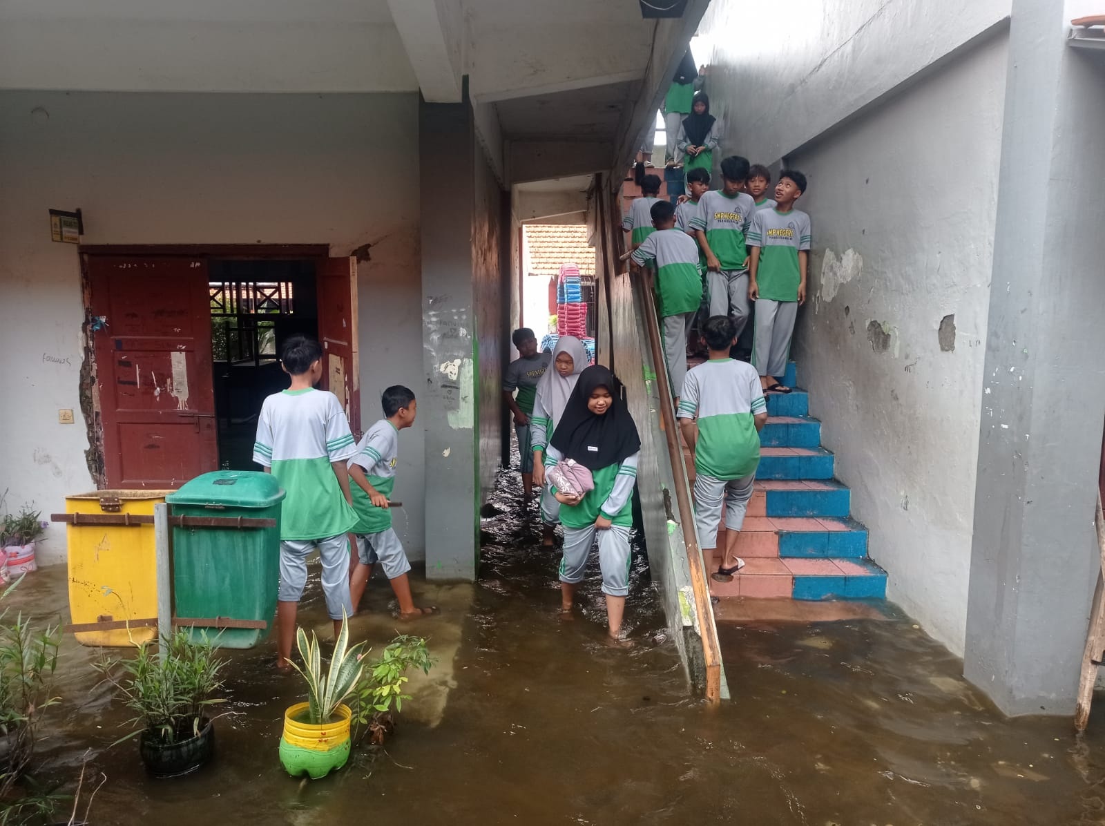 MENGGANGGU: Sejumlah siswa berada di area SMP Negeri 2 Tanggulangin yang masih terendam banjir. (SURYANTO/RADAR SIDOARJO)