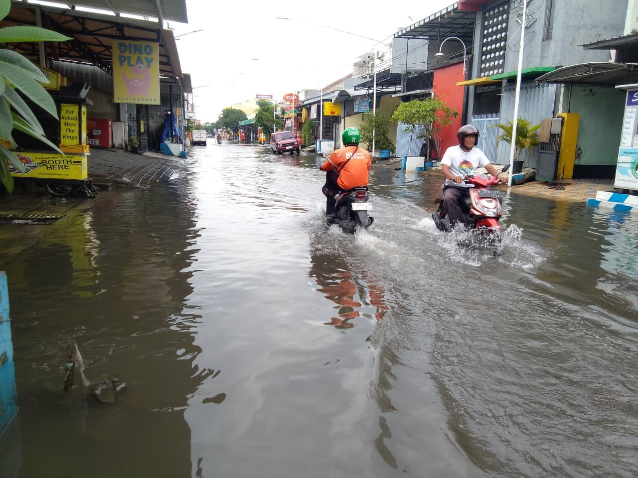TERDAMPAK: Banjir yang tak kunjung surut berdampak pada aktivitas UMKM di kawasan Tropodo, Kecamatan Waru. (DIKY SANSIRI/RADAR SIDOARJO)