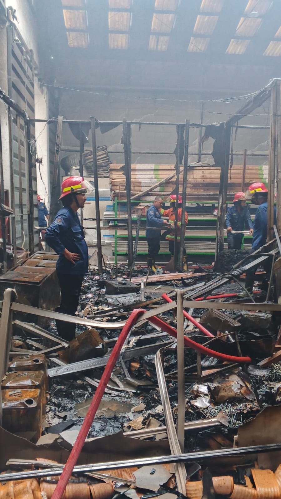 LUDES: Petugas Damkar BPBD melakukan pembahasan kantor yang terbakar.