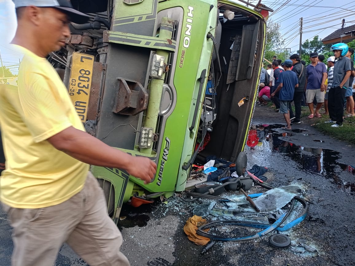 NAHAS: Truk kontainer yang terguling di Jalan Raya Balongbendo, Sidoarjo.