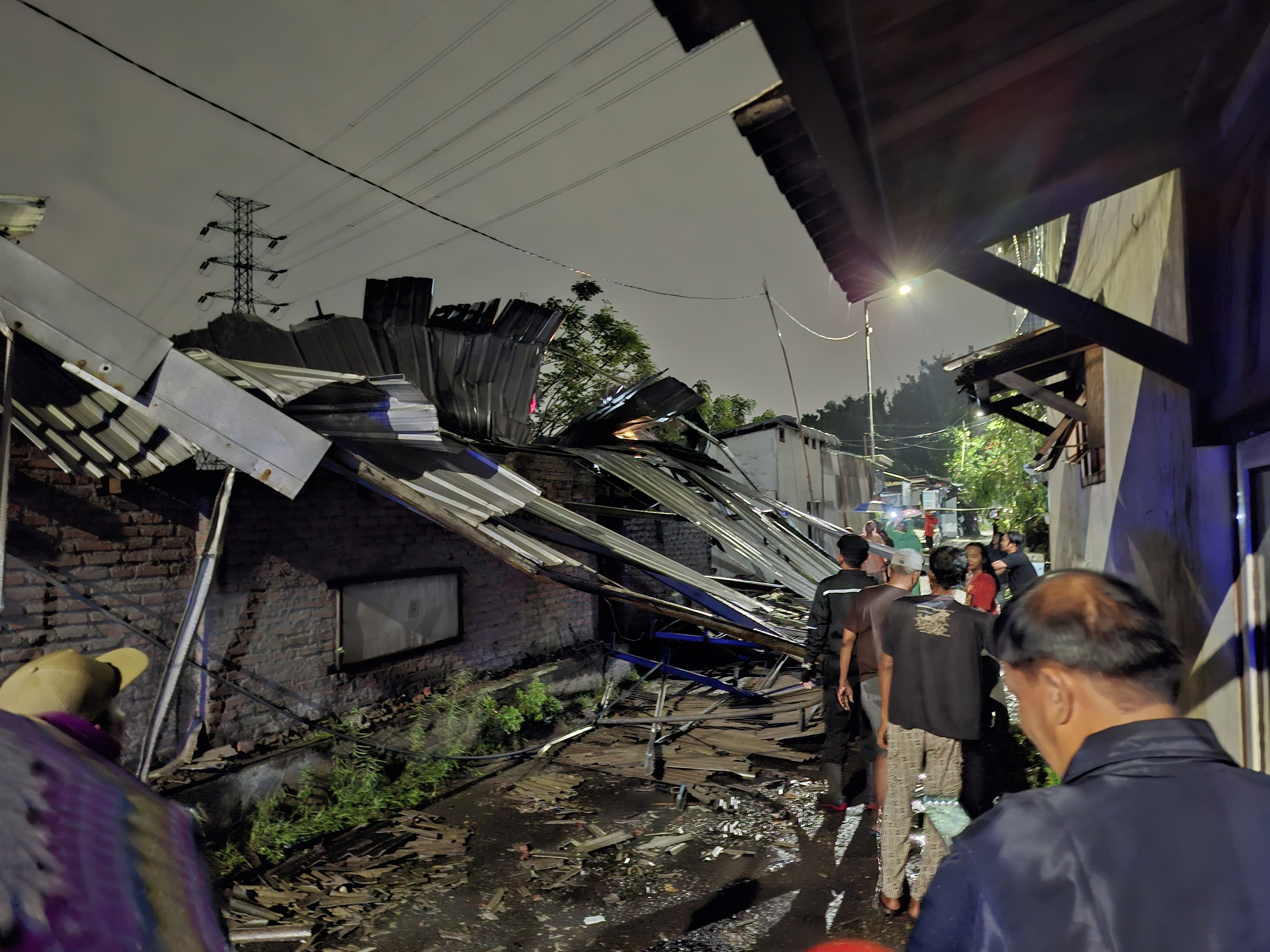 RUSAK: Warga bergotong royong membersihkan puing-puing rumah di Sepanjang, Taman, Sidoarjo, Senin (19/1).