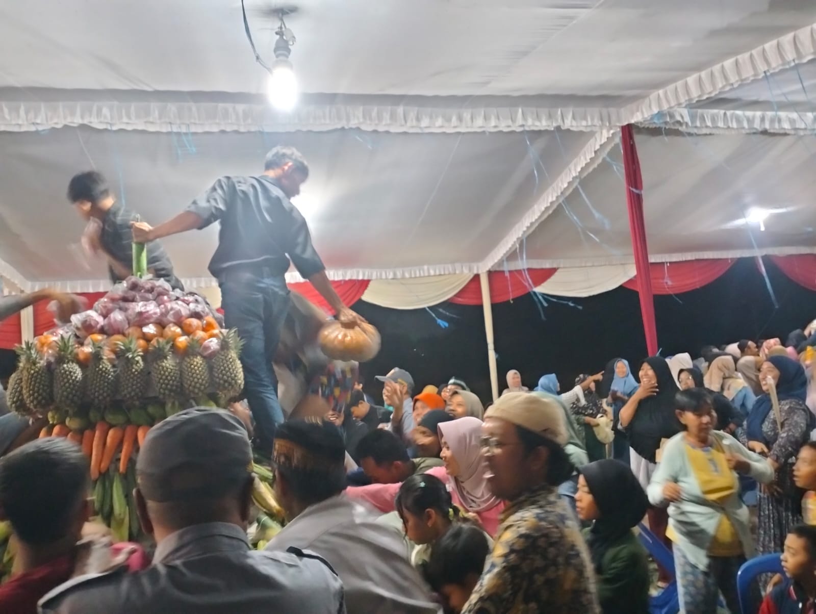 TERTIB: Warga Desa Gelam sangat antusias  saat perebutan berupa sayuran buah-buahan dari gunungan . (ANAS/RADAR SIDOARJO)