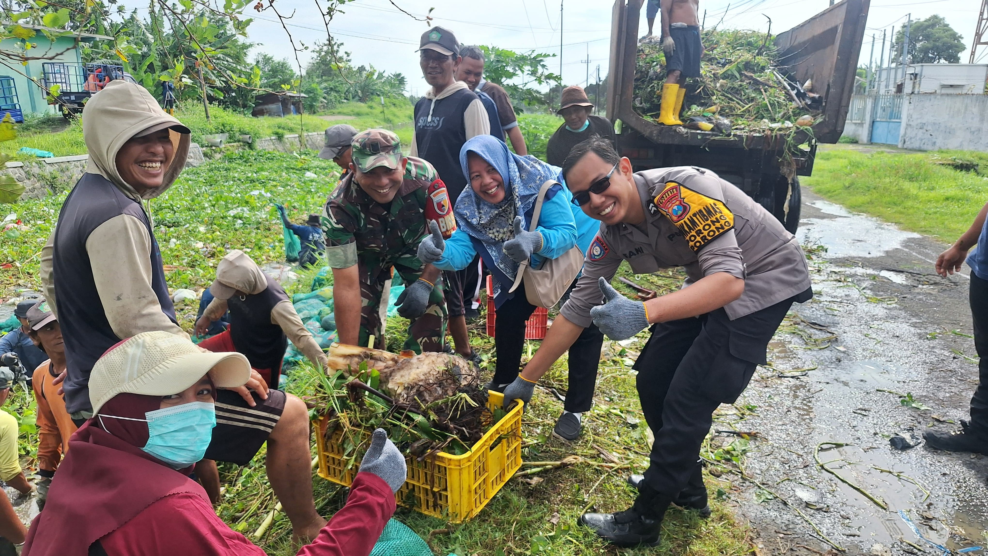KOMPAK: Personel Polsek Porong bersama warga membersihkan saluran sungai di wilayah Kelurahan Porong.
