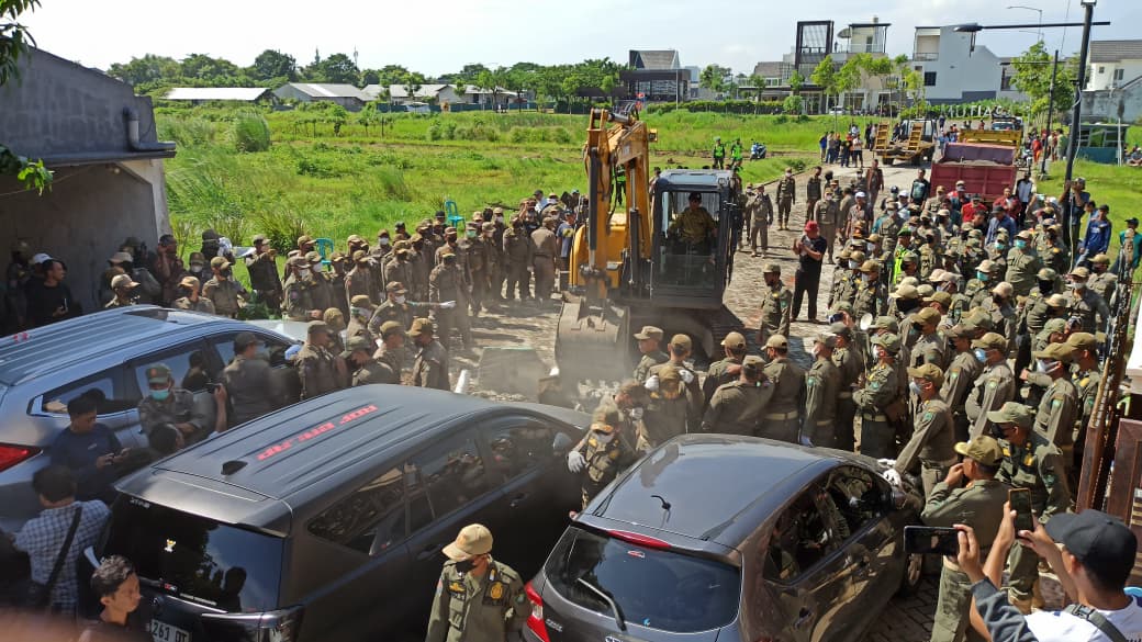 MEMANAS: Proses eksekusi tembok pembatas Mutiara Regency&ndash;Mutiara City, Sidoarjo, Kamis (29/1) yang sempat diwarnai penolakan oleh warga sekitar. (DIKY SANSIRI/RADAR SIDOARJO)