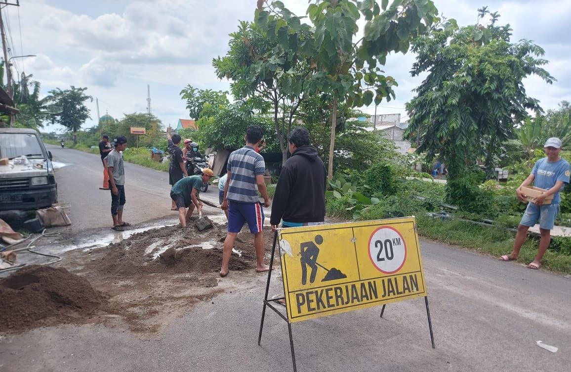 KOMPAK: Pemuda Tanjunganom, Tanjungsari, Taman, Sidoarjo, tambal jalan pakai sirtu. (DIKY SANSIRI/RADAR SIDOARJO)