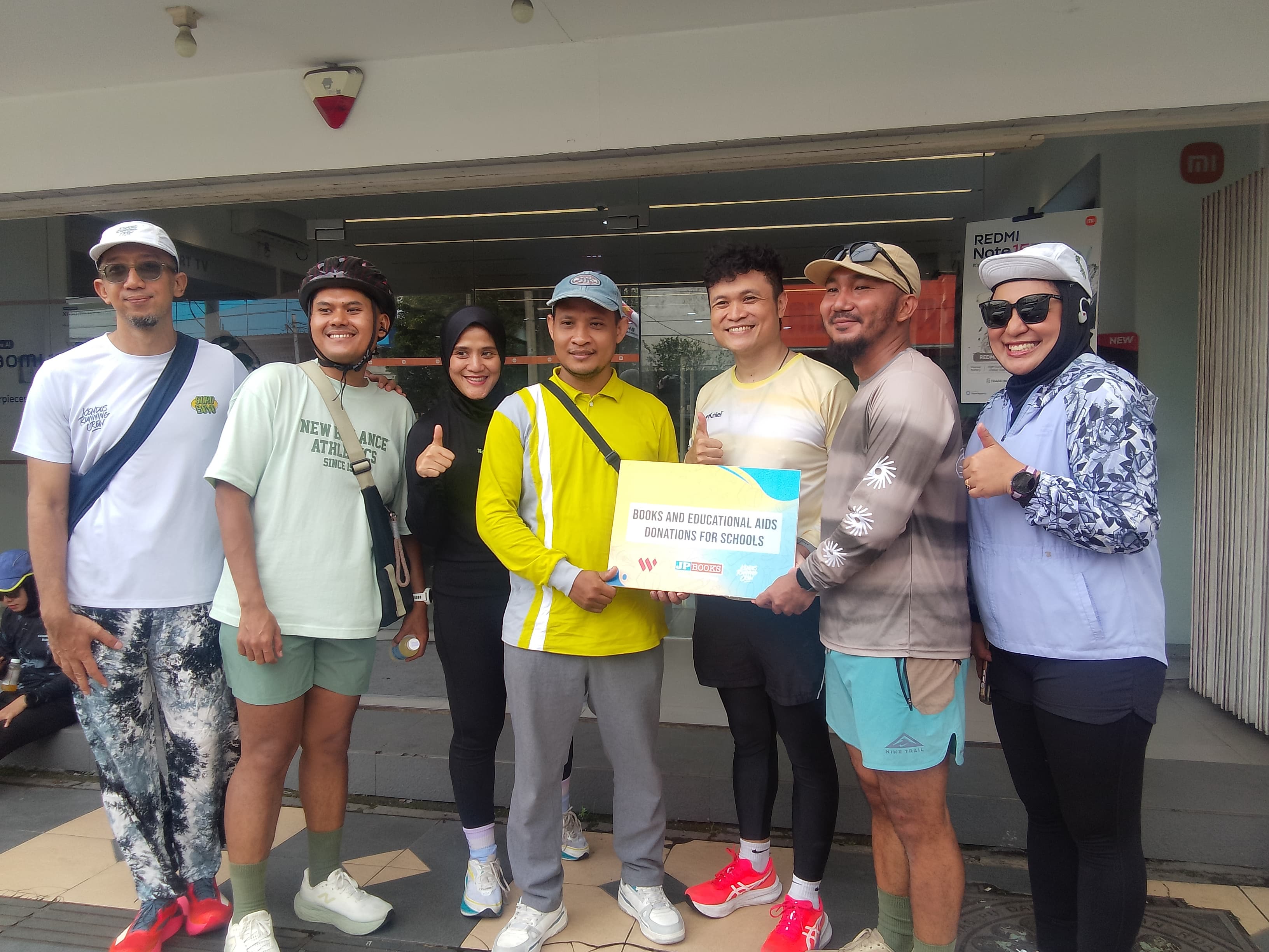 PEDULI: Pendiri Kendos Running Crew (dua dari kanan) dan Manajer Marketing JP Books (tiga dari kanan) menyerahkan buku dan alat peraga secara simbolis di Sidoarjo, Minggu (8/2). (DIKY/RADAR SIDOARJO)